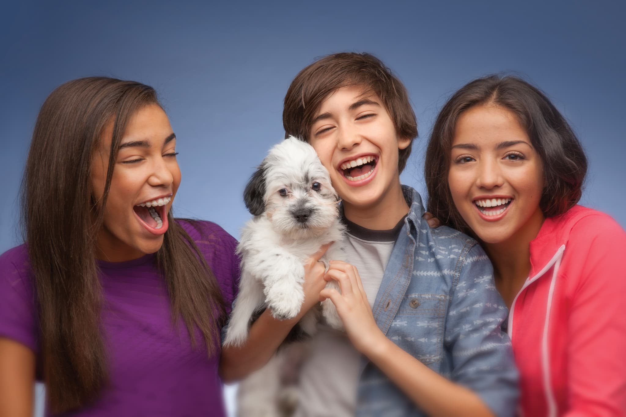 young people smiling with a dog